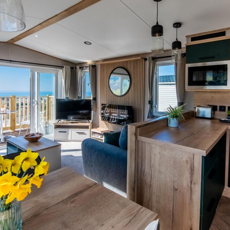 The living area viewed from the kitchen diner inside a Diamond caravan at Woolacombe Sands Holiday Park