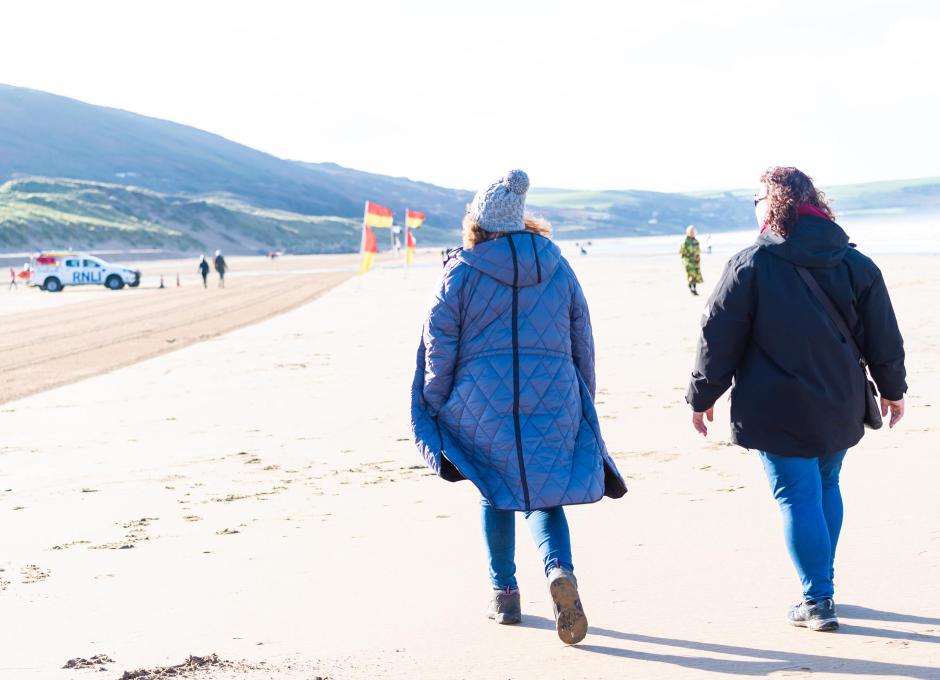 Guests from Woolacombe Sands Holiday Park walking along Woolacombe Beach on an Autumn Day