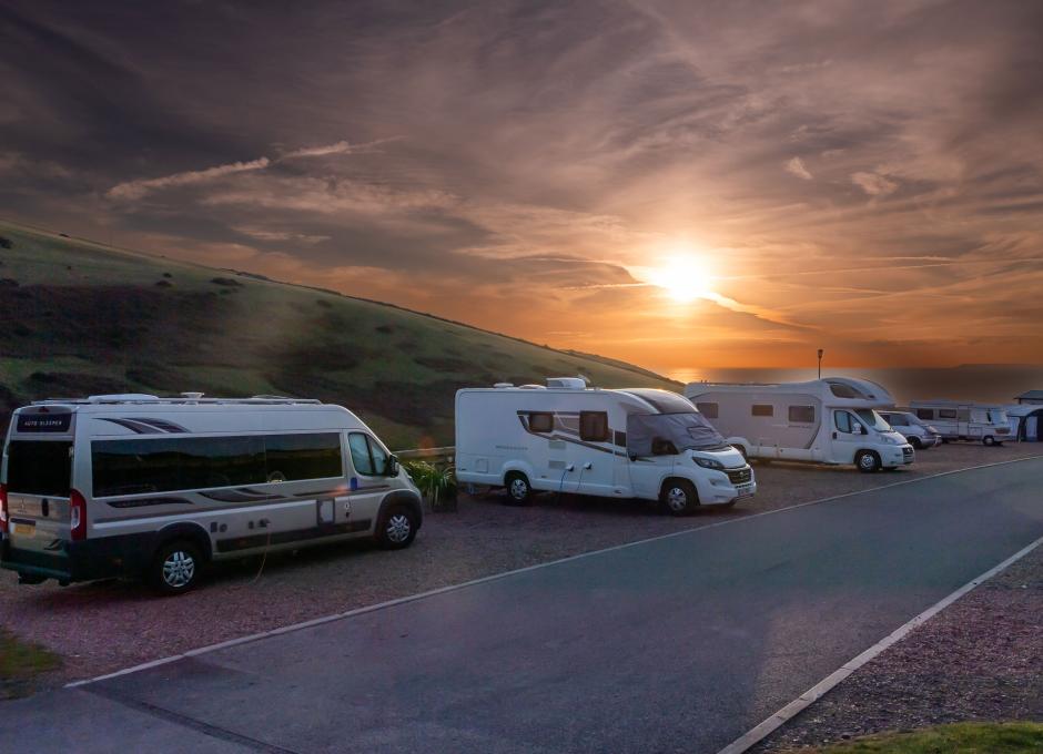 Campervans at Woolacombe Sands Holiday park with sunset in background