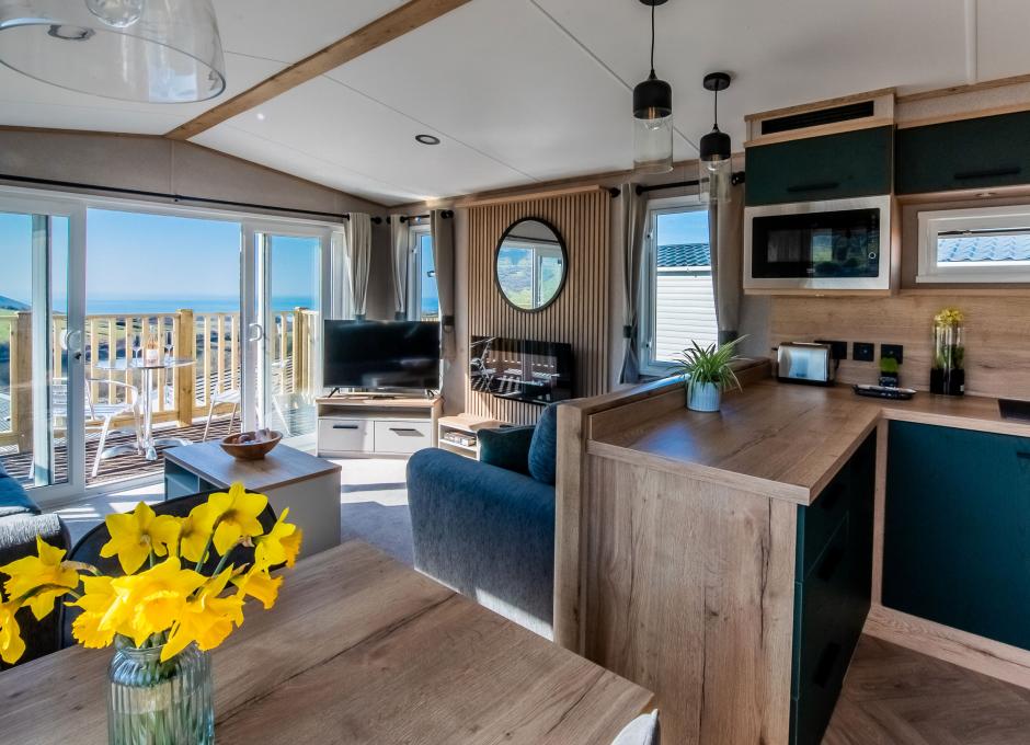 The living area viewed from the kitchen diner inside a Diamond caravan at Woolacombe Sands Holiday Park